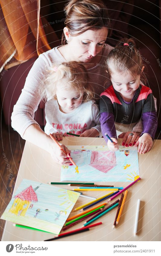 Mama mit kleinen Mädchen, die ein buntes Bild zeichnen. Lifestyle Freude Glück Handarbeit Tisch Kindererziehung Bildung Kindergarten Schule Mensch Eltern