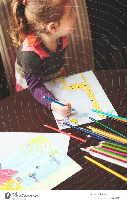 Kleines Mädchen zeichnet die bunten Bilder der Giraffe und spielen Kinder mit Bleistift Buntstifte sitzen am Tisch drinnen. Schuss von oben Lifestyle Freude
