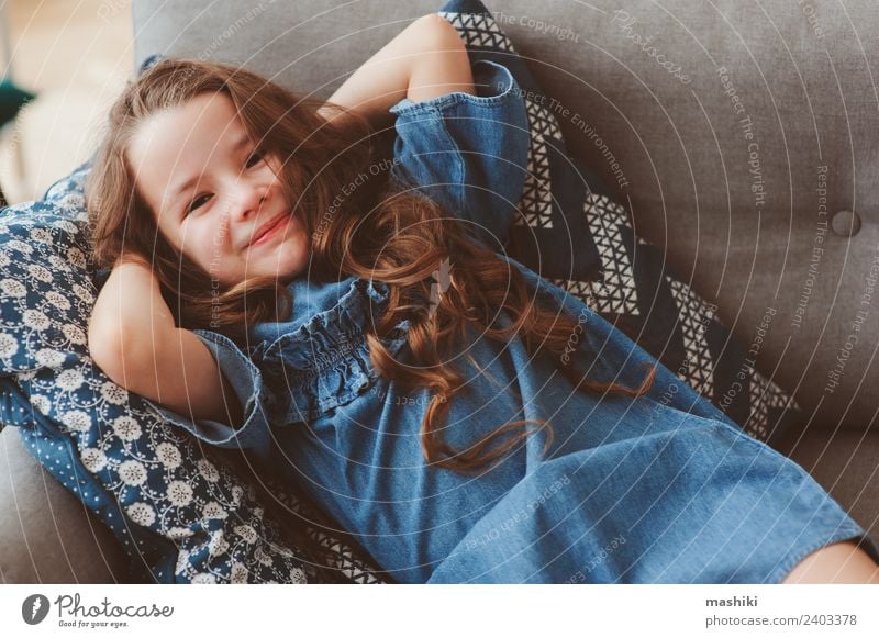 süßes glückliches 5 Jahre altes Kind Mädchen Lifestyle Freude Glück Erholung Wohnzimmer Frau Erwachsene Kindheit Mode Kleid Lächeln sitzen träumen Coolness