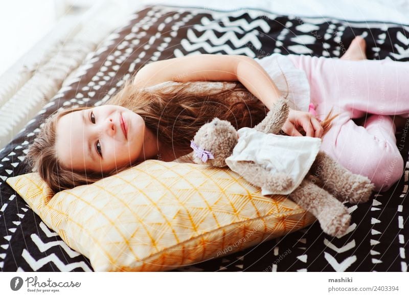 süßes glückliches Kind Mädchen entspannend zu Hause Lifestyle Freude Erholung Schlafzimmer Lächeln schlafen träumen klein lustig Energie Bett aufwachen