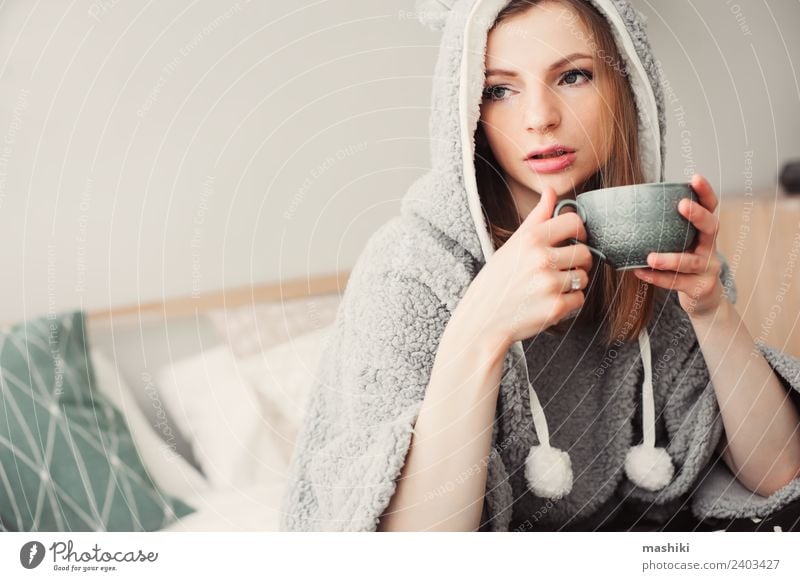 junge schöne Frau, die sich zu Hause entspannt. Kaffee Tee Lifestyle Leben Erholung Schlafzimmer Erwachsene Kultur Wärme Mode sitzen träumen modern natürlich