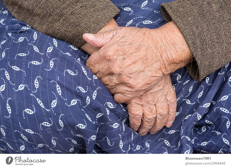 Ein Detail einer alten Frau, die ihren traditionellen Rock anlegt. Lifestyle Körper Haut Leben Ruhestand Mensch feminin Erwachsene Großmutter Hand Finger Stoff