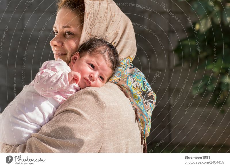 Muslimische Mutter, die ein kleines Neugeborenes im Freien betreut. Lifestyle schön Leben Erholung Kindererziehung Mensch feminin Baby Frau Erwachsene Eltern