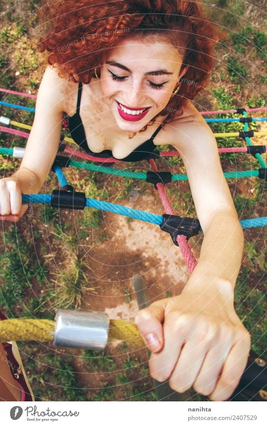 Junge rothaarige Frau beim Klettern in einem Park Lifestyle Stil Freude schön Haare & Frisuren Sommersprossen Wellness Leben Fitness Sport-Training üben Mensch
