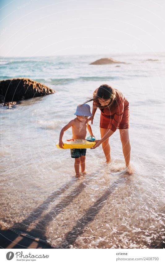 Mutter und Sohn beim Vergnügen mit dem aufblasbaren Ring am Strand Lifestyle Freude Glück Freizeit & Hobby Spielen Ferien & Urlaub & Reisen Sonne Meer Kind
