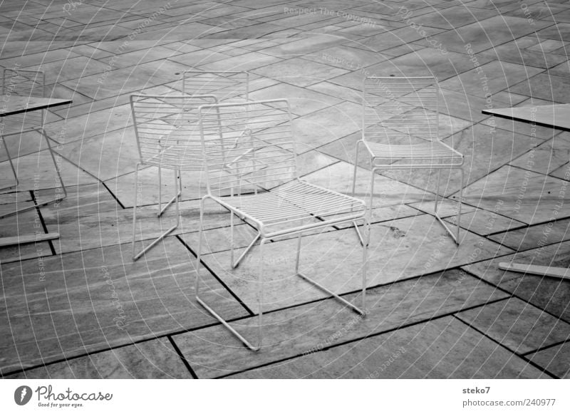 Stühle rücken Stein leer Linie Stuhl Tisch Schwarzweißfoto Außenaufnahme Menschenleer grau Bodenplatten außergewöhnlich