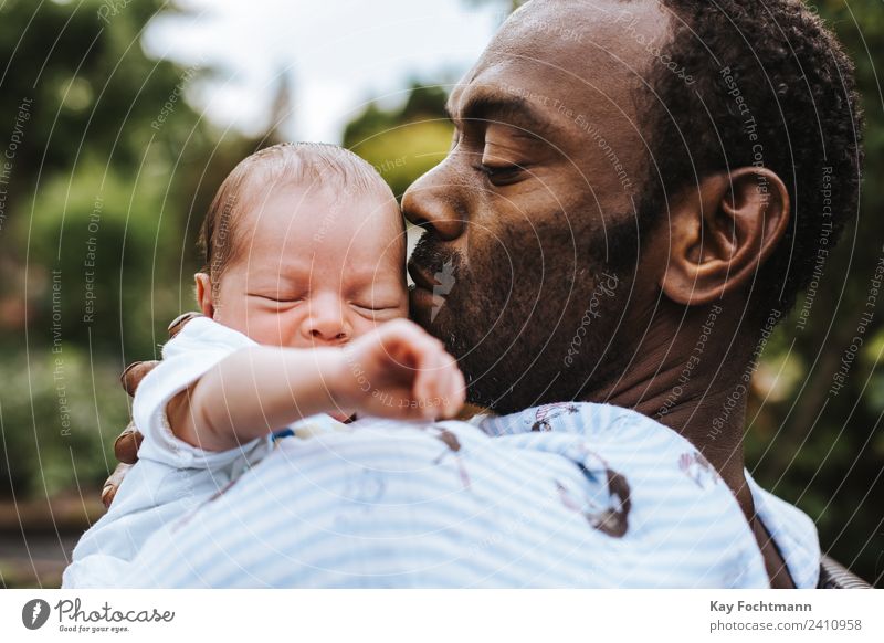 Schwarzer Vater hält neugeborenen Sohn in den Armen Leben Kind Mensch Baby Mann Erwachsene Familie & Verwandtschaft 2 0-12 Monate 30-45 Jahre schwarzhaarig