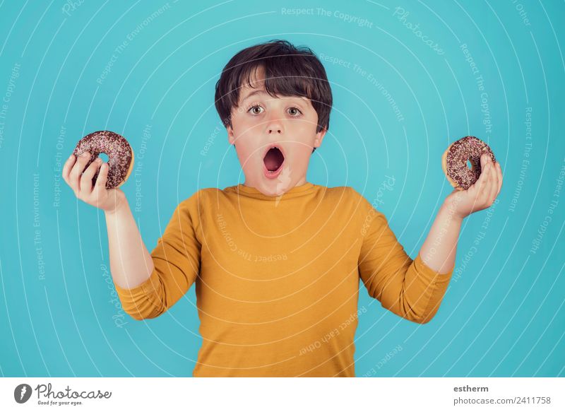 überraschter Junge mit Donuts in der Hand Lebensmittel Brötchen Süßwaren Schokolade Ernährung Frühstück Mittagessen Lifestyle Freude Mensch maskulin Kind