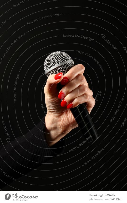 Damenhandmikrofon auf schwarzem Hintergrund Mensch Frau Erwachsene Hand 1 Schauspieler Show Musik Konzert Bühne Sänger Musiker Schallplatte Medien Fernsehen rot