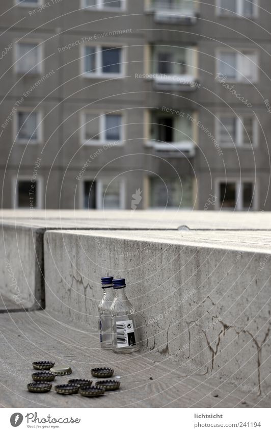 abwärts Alkohol Spirituosen trinken Stadt Hauptstadt Stadtrand Haus Hochhaus Platz Treppe Fassade Fenster Beton grau Verfall Verzweiflung schäbig Kronkorken