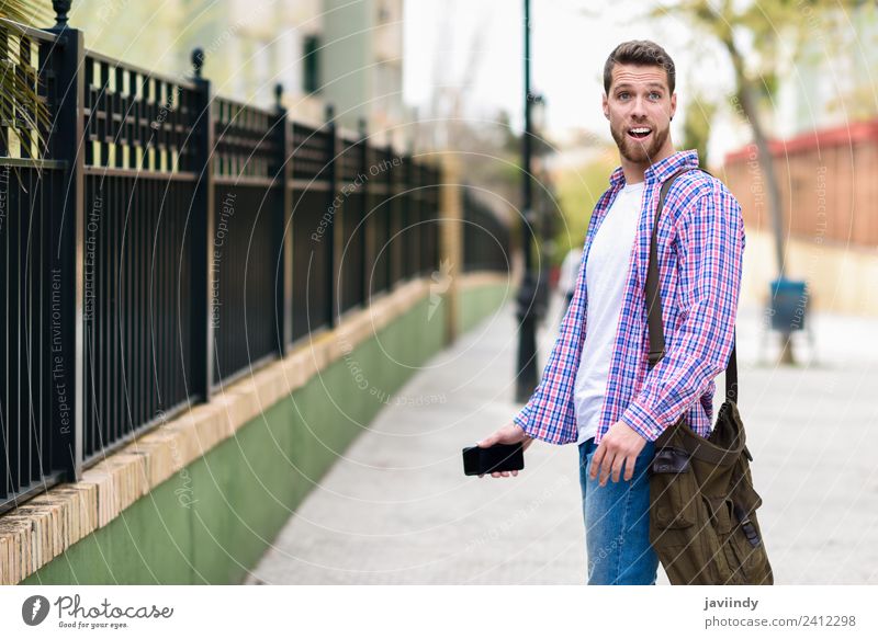 Junger bärtiger Mann überrascht im urbanen Hintergrund Lifestyle Stil Glück Ferien & Urlaub & Reisen Telefon PDA Mensch Junger Mann Jugendliche Erwachsene 1
