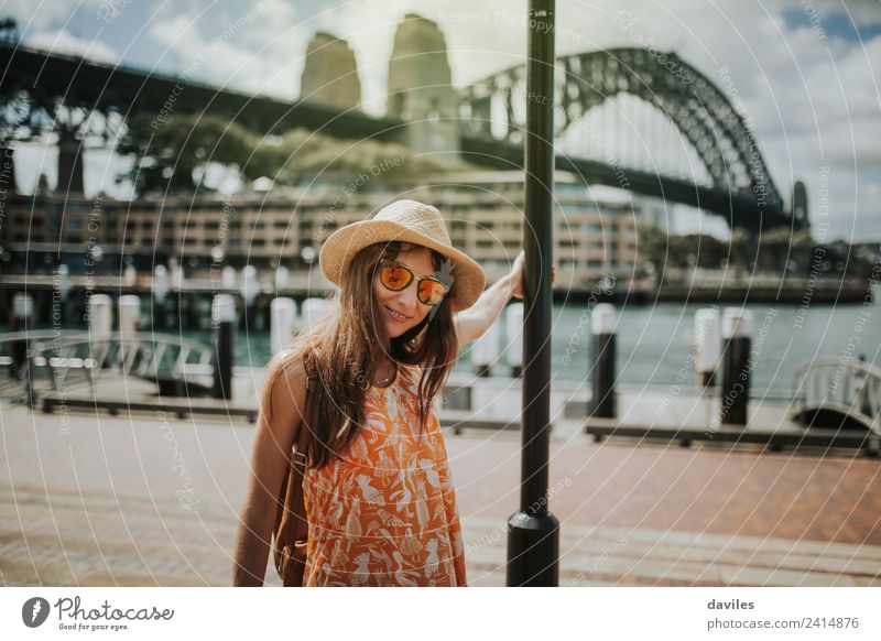 Süßes Mädchen mit Hut und Sonnenbrille posiert in der Stadt Sydney, mit der Harbour Bridge im Hintergrund, Australien. Lifestyle Ferien & Urlaub & Reisen