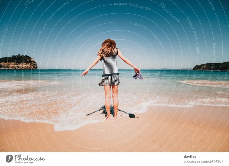 Frau mit einem Kleid und einem Hut, die in der Bucht von Maitland, NSW, Australien, ins Strandwasser geht. Lifestyle Ferien & Urlaub & Reisen Tourismus