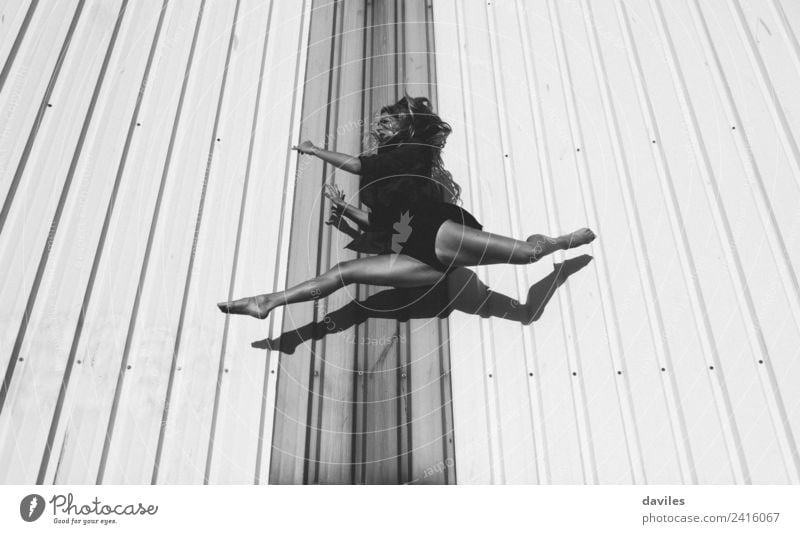 Schwarz-Weiß-Porträt von Tänzerin springen und schwebte, mit einer industriellen Wand im Hintergrund Lifestyle Freizeit & Hobby Sport Fitness Sport-Training