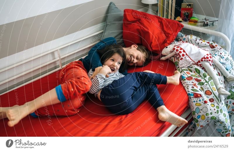Bruder und Schwester kitzeln und lachen auf dem Bett Lifestyle Freude Glück Spielen Schlafzimmer Kind Mensch Junge Frau Erwachsene Mann Familie & Verwandtschaft