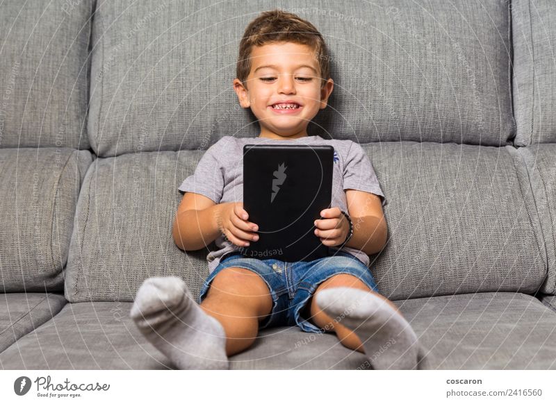 Kleiner Junge mit einem Tablett Glück Freizeit & Hobby Spielen Sofa Kind Schule Computer Notebook Bildschirm Technik & Technologie Internet Baby Kleinkind