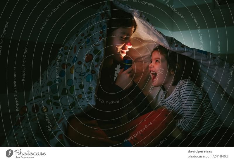 Junge mit Schwester leuchtet mit Taschenlampe Lifestyle Freude Glück schön Windstille Schlafzimmer Kind Mensch Frau Erwachsene Mann Familie & Verwandtschaft