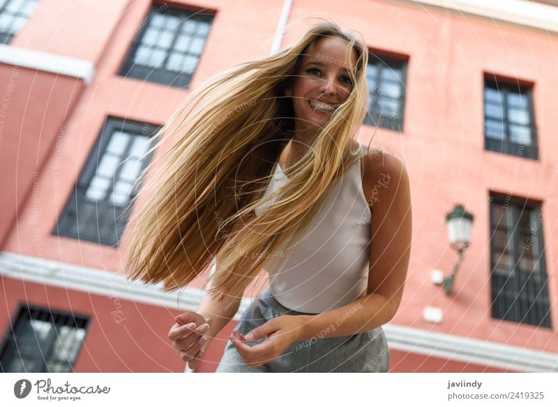 Glückliche junge Frau mit beweglichen Haaren im urbanen Hintergrund Lifestyle elegant Stil schön Haare & Frisuren Sommer Mensch feminin Junge Frau Jugendliche