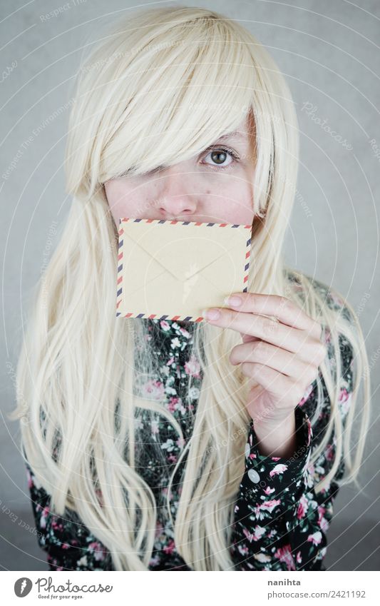 Junge blonde Frau, die ihren Mund mit einem Umschlag bedeckt. Design Haare & Frisuren Haut Gesicht Post Briefumschlag Adressat Einladung Absender Mensch feminin