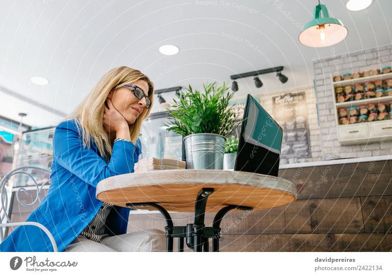 Frau, die mit dem Laptop arbeitet Tisch Arbeit & Erwerbstätigkeit Arbeitsplatz Business Computer Notebook Internet Mensch Erwachsene Pflanze blond fahren sitzen