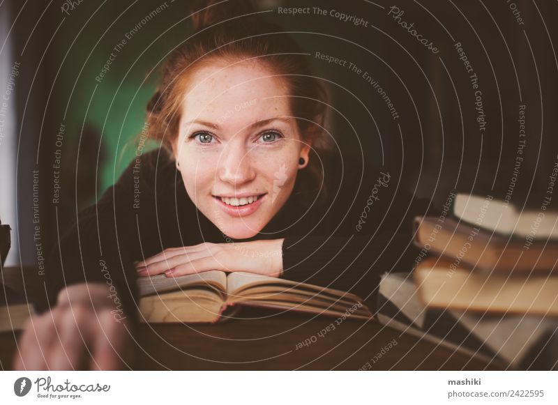 Innenporträt einer rothaarigen glücklichen Frau beim Lernen Lifestyle Erholung lesen Tisch Studium Erwachsene Buch Bibliothek Pullover lernen träumen dunkel