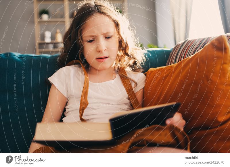 konzentriertes Kind Mädchen lesen interessantes Buch zu Hause Lifestyle Erholung Schulkind Kindheit Bibliothek authentisch klein klug heimwärts Bildung lernen