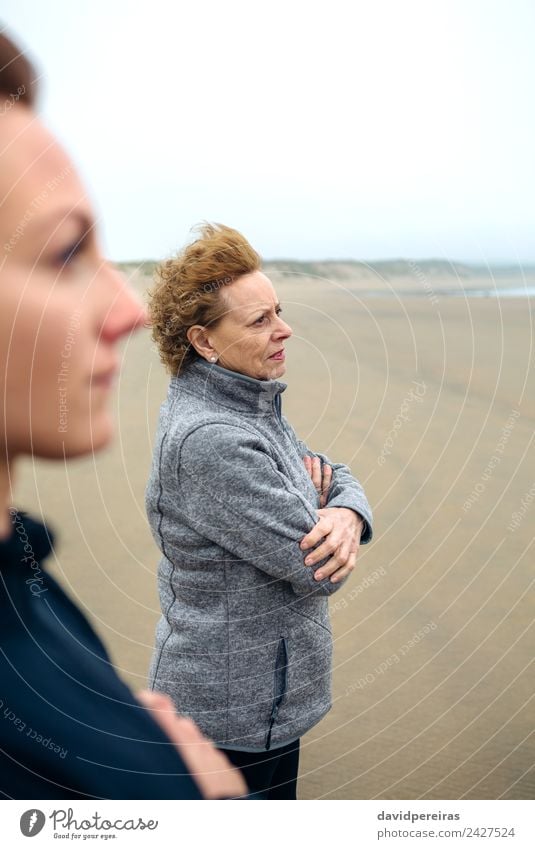 Zwei Frauen, die auf das Meer schauen. Lifestyle schön Meditation Strand Mensch Erwachsene Mutter Großmutter Familie & Verwandtschaft Sand Herbst Wind Nebel