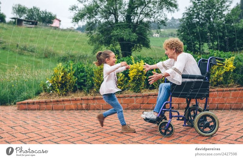 Enkelin läuft zur Großmutter im Rollstuhl Lifestyle Glück Gesundheitswesen Erholung Garten Mensch Frau Erwachsene Familie & Verwandtschaft Natur Pflanze Baum