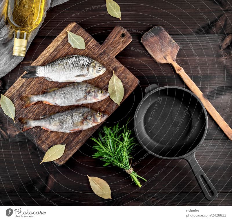 drei Flussfische auf einem braunen Holzbrett Fisch Meeresfrüchte Kräuter & Gewürze Ernährung Abendessen Diät Pfanne Tisch Essen dunkel frisch oben retro schwarz