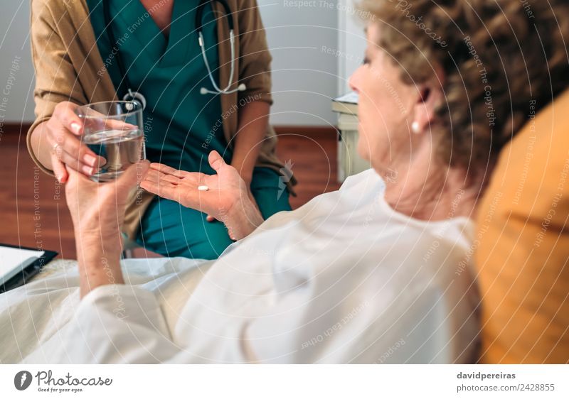 Ärztin gibt älteren Patienten Medikamente Gesundheitswesen Behandlung Krankheit Haus Arzt Krankenhaus Mensch Frau Erwachsene alt authentisch Geben Tablette