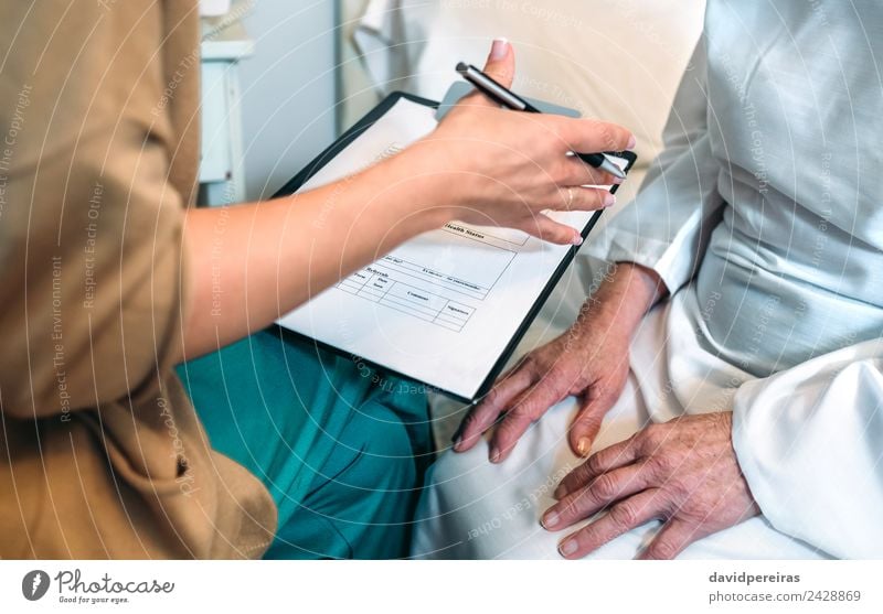 Eine Ärztin füllt einen Fragebogen für einen älteren Patienten aus Gesundheitswesen Krankheit Medikament Arzt Krankenhaus Mensch Frau Erwachsene Hand