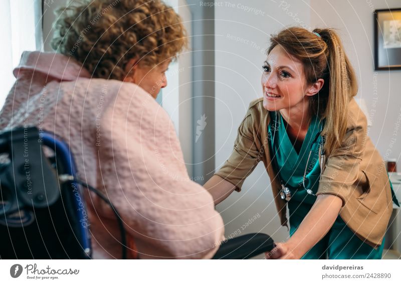 Weibliche Ärztin im Gespräch mit älterem Patienten im Rollstuhl Gesundheitswesen Krankheit Erholung Arzt Krankenhaus sprechen Mensch Frau Erwachsene alt