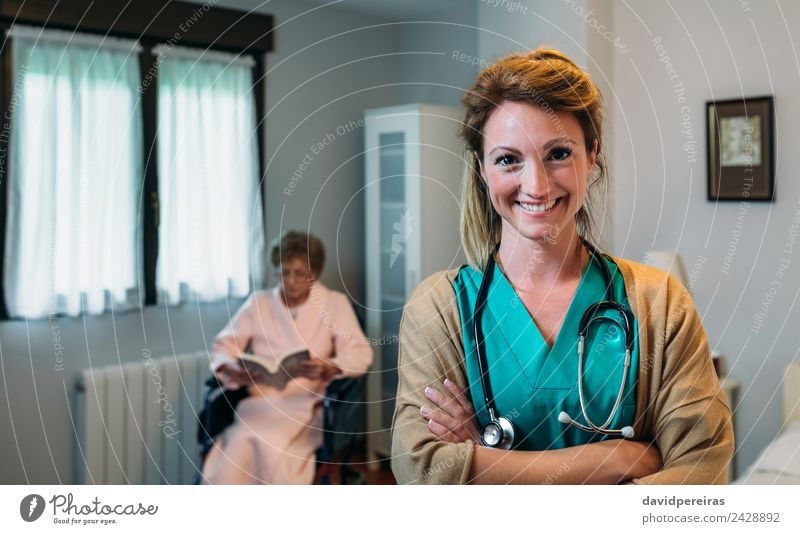 Hübsche Ärztin in einer geriatrischen Klinik mit einer älteren Frau im Rollstuhl Glück Gesundheitswesen Krankheit Erholung lesen Schlafzimmer Arzt Krankenhaus