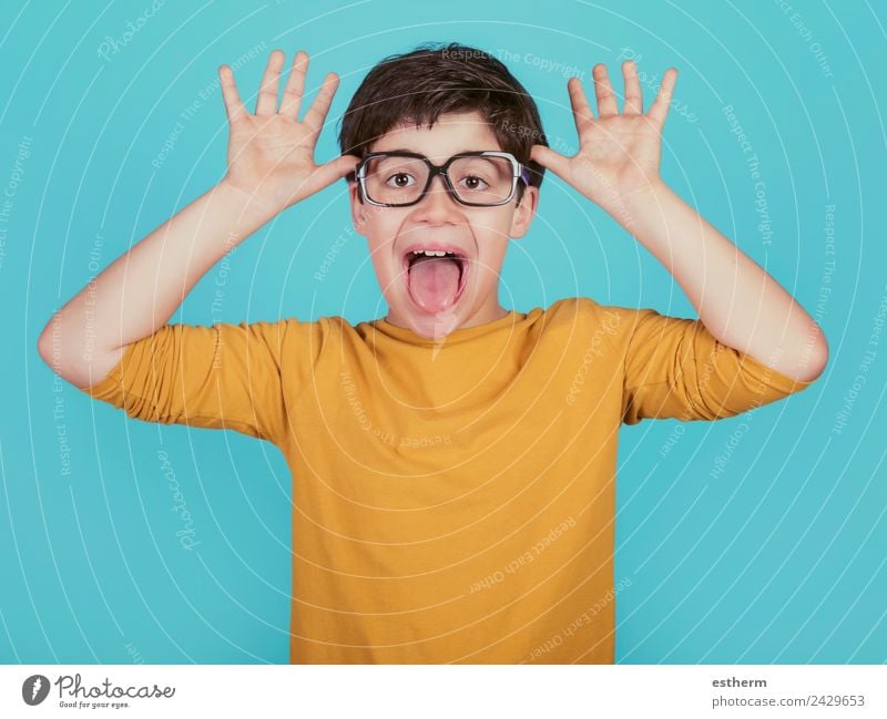 lustiger Junge mit Brille zeigt seine Zunge heraus auf blauem Hintergrund Lifestyle Freude Mensch maskulin Kind Kleinkind Kindheit 1 8-13 Jahre Fitness Lächeln