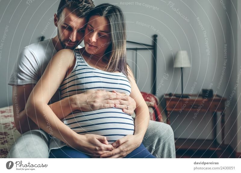 Schwangere Frau, die von ihrem Mann umarmt wird. ruhig Schlafzimmer Mensch Baby Erwachsene Eltern Mutter Vater Familie & Verwandtschaft Paar Partner Hand Liebe