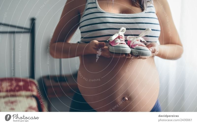 Schwangerschaft zeigt Babysneakers Lifestyle Leben Mensch Frau Erwachsene Mutter Schuhe Turnschuh warten authentisch nackt schwanger rosa Vorfreude Erwartung