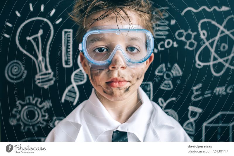 Kleiner Chemiker in der Brille, der die Kamera ernsthaft ansieht. Gesicht Wohnung Wissenschaften Kind Schule Klassenraum Tafel Labor Mensch Junge Kindheit