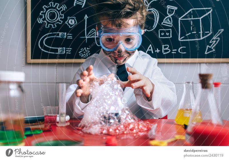 Glückliches Kind macht Experimente mit Seifenschaum. Gesicht Spielen Wohnung Tisch Wissenschaften Schule Klassenraum Tafel Labor Mensch Junge Arme Hand Lächeln