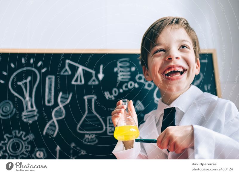 Happy Kig lacht und zeigt Flüssigkeit in der Flasche. Glück Spielen Wohnung Wissenschaften Kind Klassenraum Tafel Labor Mensch Junge Kindheit Lächeln lachen