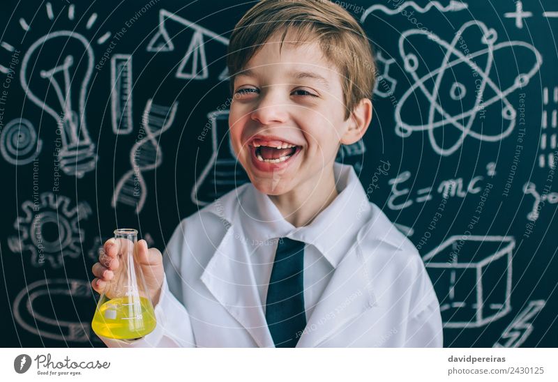 Glückliche kleine Wissenschaftlerin lacht, während sie den Kolben hält Spielen Wohnung Wissenschaften Kind Klassenraum Tafel Labor Mensch Junge Kindheit Lächeln