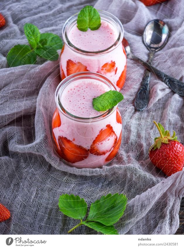 Smoothies von frischen Erdbeeren Joghurt Milcherzeugnisse Frucht Dessert Frühstück Diät Getränk Saft Glas Löffel Sommer Tisch Holz saftig grün rot Milchshake