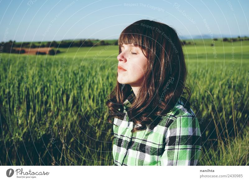 Junge Frau genießt die Sonne auf einer grünen Wiese Lifestyle schön Gesundheit harmonisch Wohlgefühl Sinnesorgane Erholung ruhig Meditation Landwirtschaft