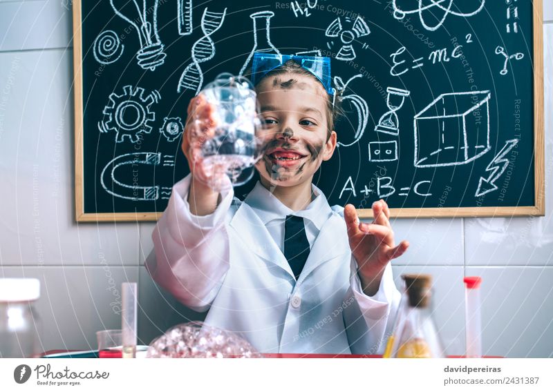 Kleiner Junge Wissenschaftler hält Glas mit Seifenschaum gegen Tafel Glück Gesicht Spielen Wohnung Tisch Wissenschaften Kind Schule Klassenraum Labor Mensch