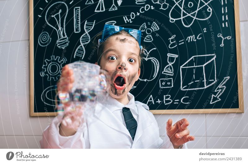 Glücklicher kleiner Junge hält Glas mit Seifenschaum. Gesicht Spielen Wohnung Tisch Wissenschaften Kind Schule Klassenraum Tafel Labor Mensch Kindheit