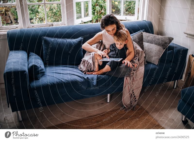 Kaukasische Mutter und Kleinkind Sohn auf der Couch sitzend mit Tablette Lifestyle Freude Glück Haus Sofa Kind Technik & Technologie Frau Erwachsene Eltern