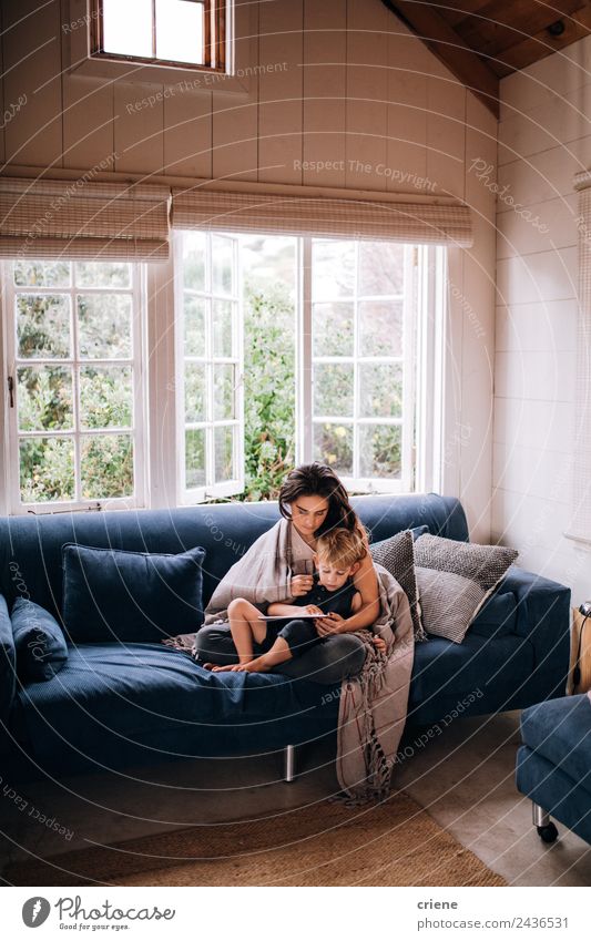 kaukasische Mutter und Sohn beim Entspannen mit Tablette auf der Couch Lifestyle Stil Freude Glück Haus Sofa Kind Technik & Technologie Kleinkind Frau