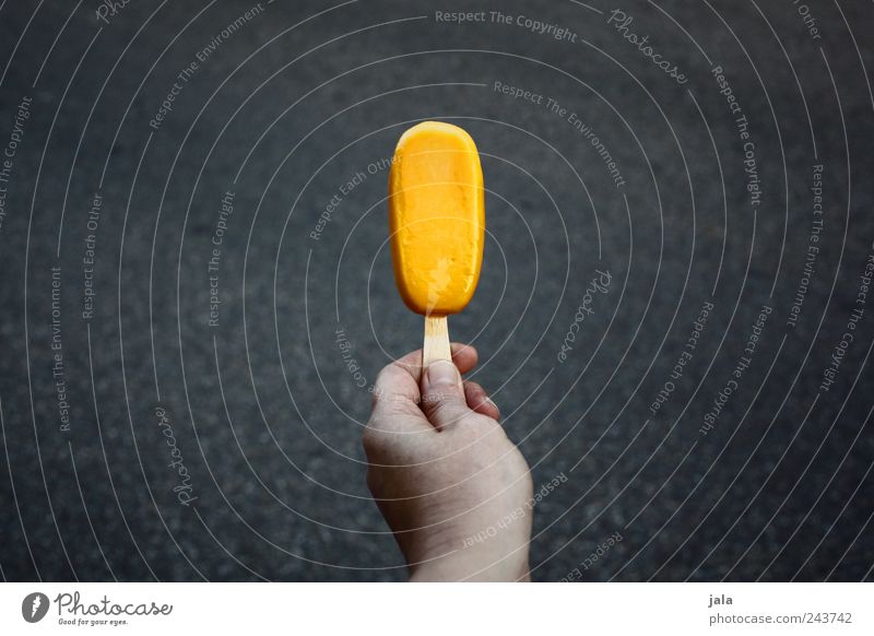 eis am stiel Lebensmittel Speiseeis Süßwaren Fingerfood Hand lecker süß gelb grau Farbfoto Außenaufnahme Menschenleer Textfreiraum links Textfreiraum rechts