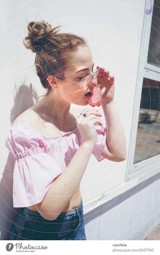 Junge Frau beim Essen eines Eises an einem Sommertag Lebensmittel Speiseeis Ernährung Lifestyle Stil schön Haare & Frisuren Wellness Erholung