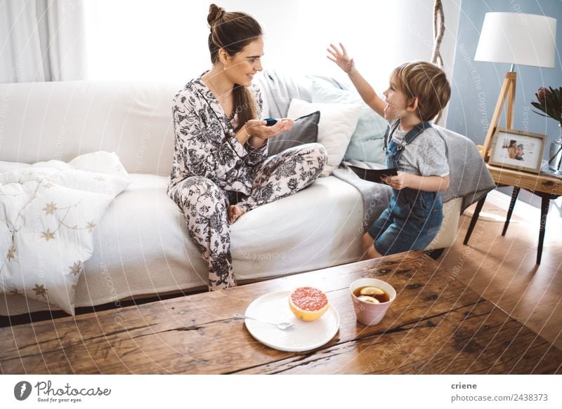glücklicher kleiner Junge, der der Mutter zu Hause im Wohnzimmer ein Geschenk macht. Frucht Tee Lifestyle Glück schön Leben Erholung Spielen Tisch Kind