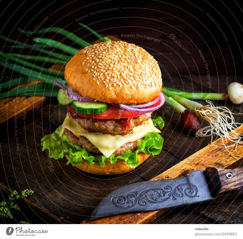 doppelter Cheeseburger mit Gemüse Fleisch Käse Brot Brötchen Mittagessen Fastfood Messer Tisch Restaurant Holz Essen frisch groß lecker grün schwarz Hamburger